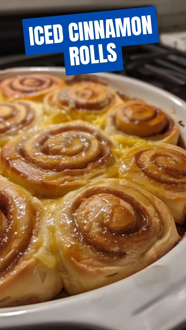 Freshly baked homemade cinnamon rolls with icing on a cooling rack.