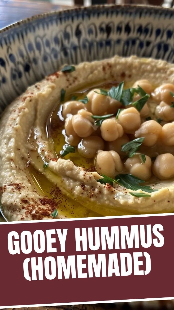 A bowl of fresh homemade hummus garnished with olive oil and parsley.
